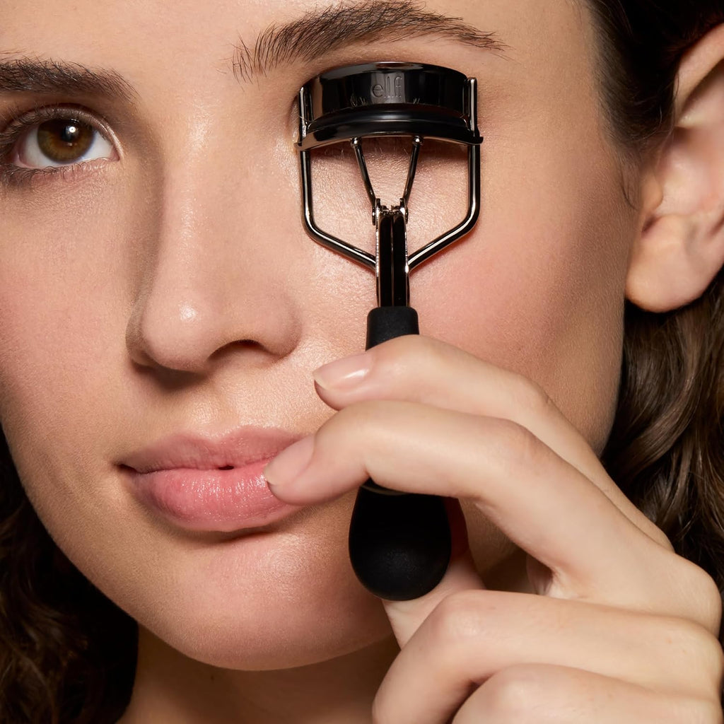 Pro Eyelash Curler being used by a woman for beautifully lifted lashes, showcasing ergonomic design and sleek finish.