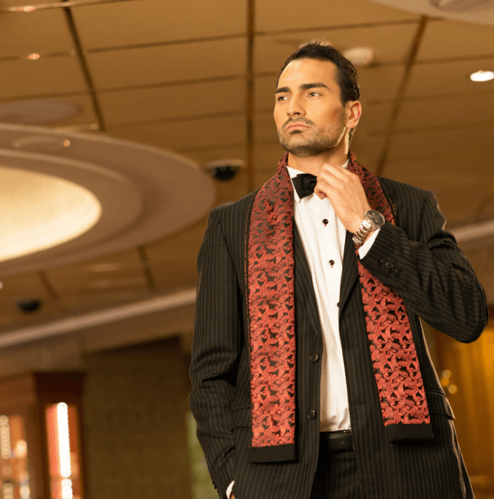 Man in a tuxedo with a red patterned scarf showcasing elegance and style.