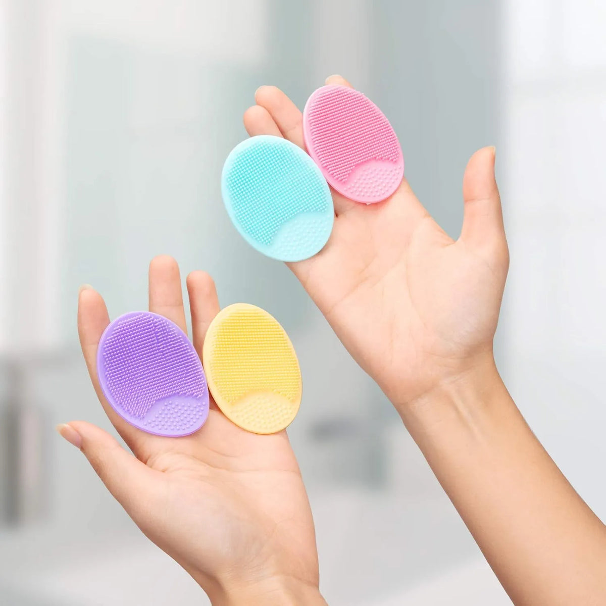 4-Pack Silicone Facial Cleansing Scrubbers in colorful silicone pads shown in hands.