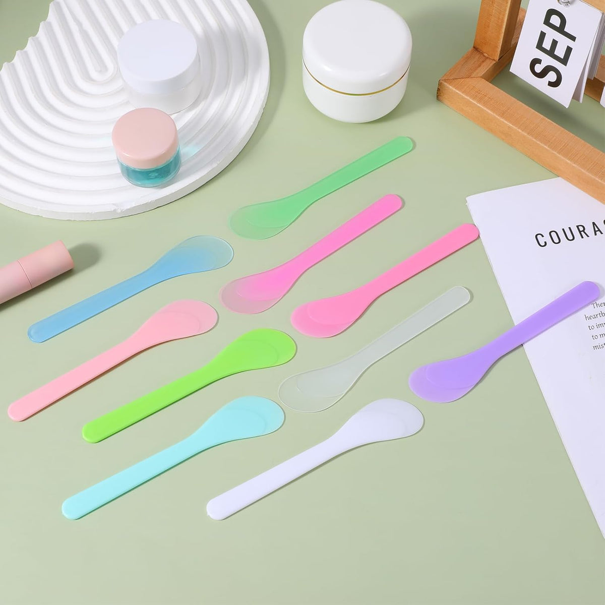 Reusable Cosmetic Spatula Set displayed on a table, featuring 10 assorted spatulas for easy skincare application.