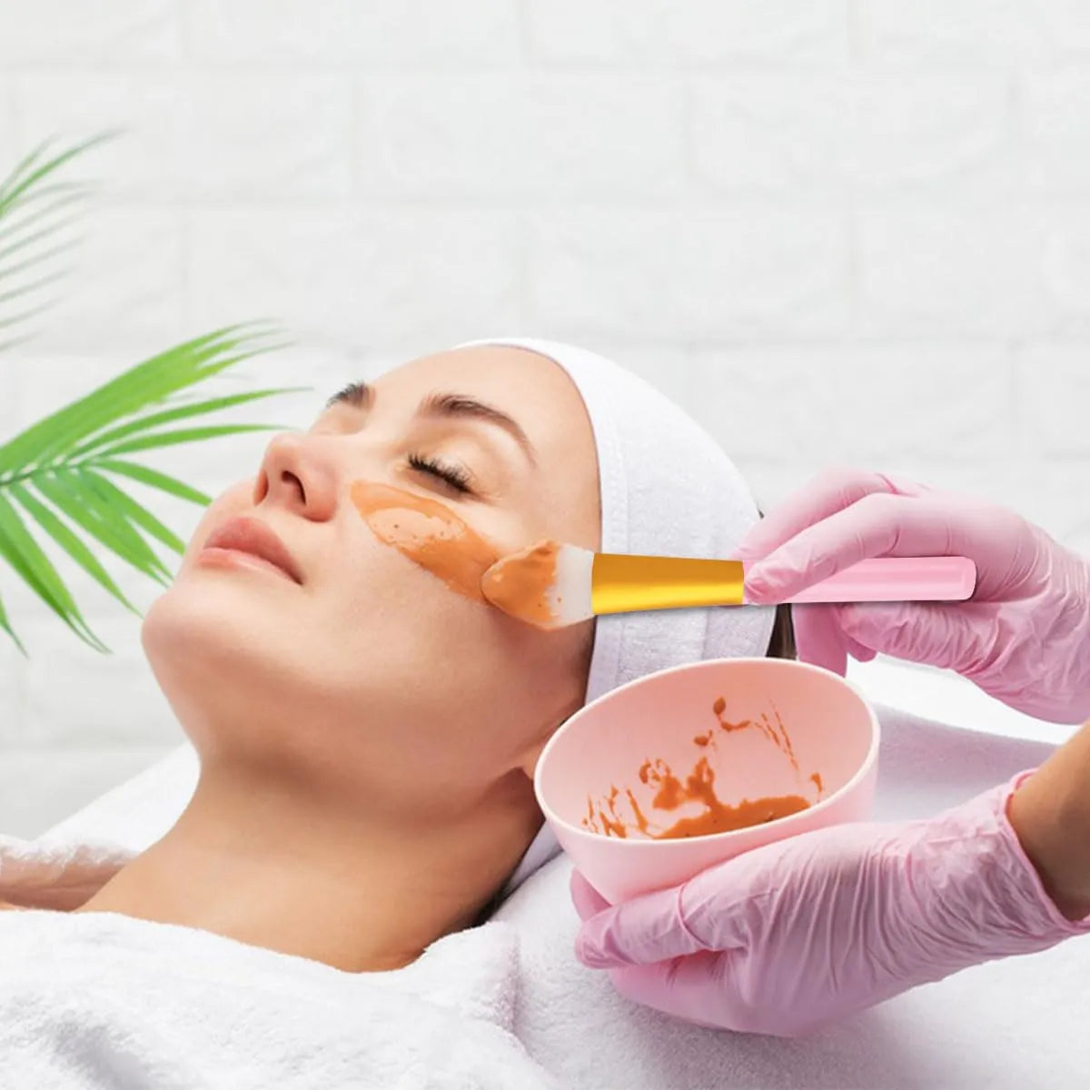 Woman using a 2-Piece Silicone Face Mask Applicator Brush Set to apply skincare on her face.